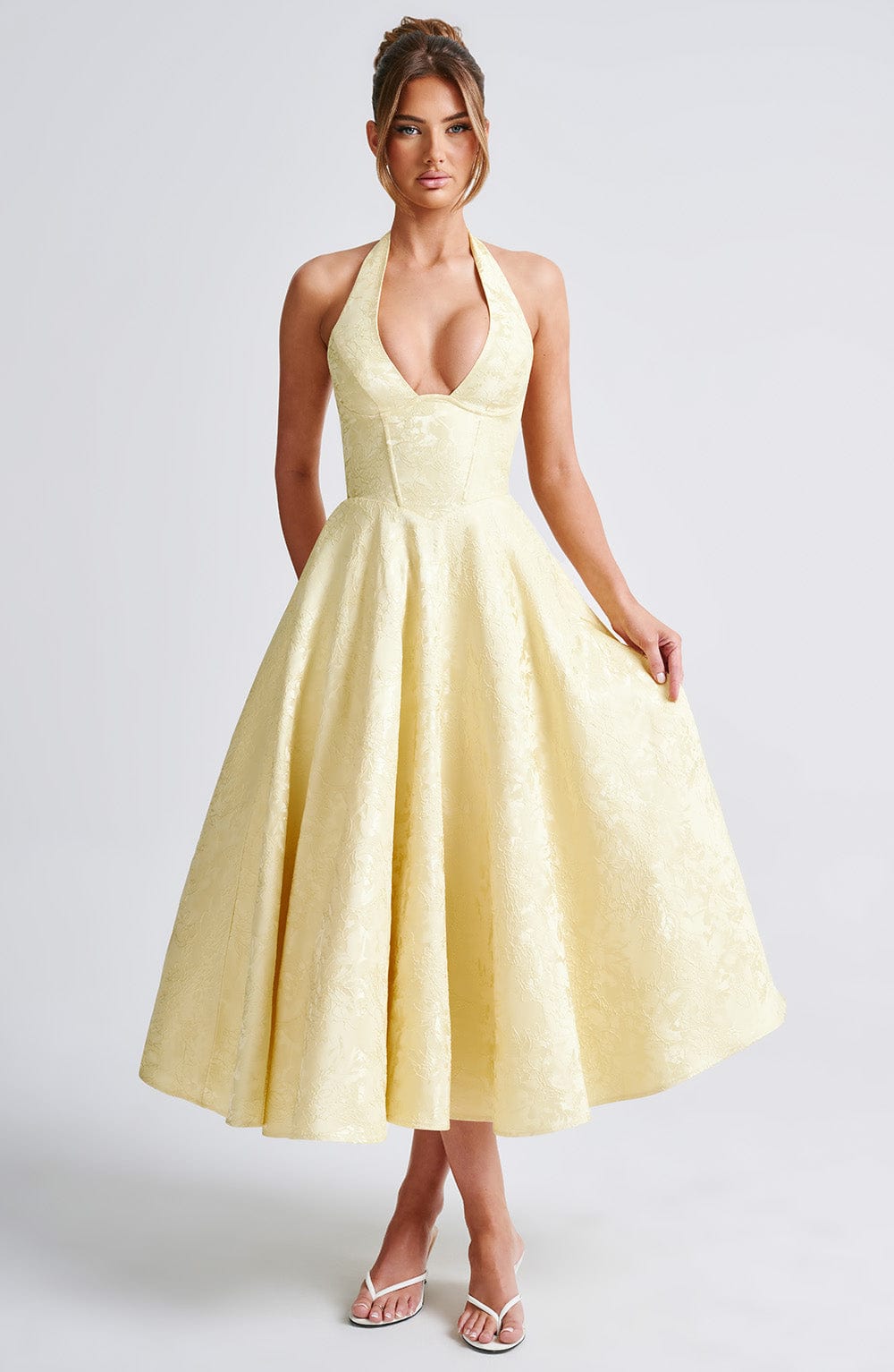 Elegant women's halter neck midi dress paired with accessories, showcasing a complete look.