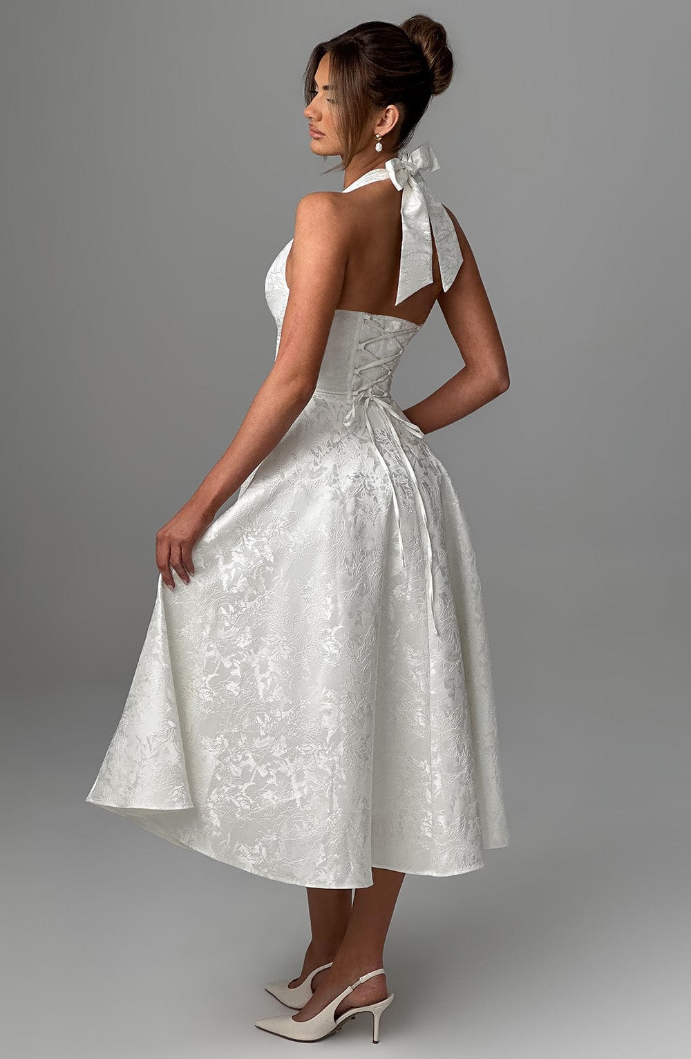 Full shot of a women's elegant halter neck midi dress, highlighting its graceful drape.