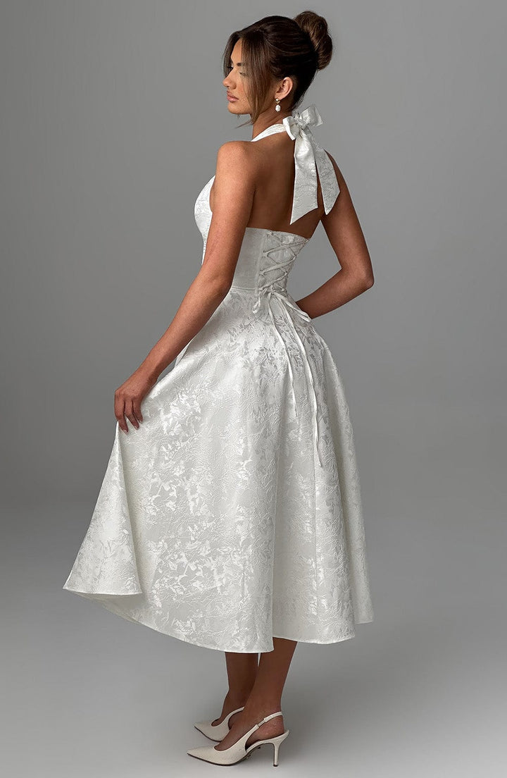 Full shot of a women's elegant halter neck midi dress, highlighting its graceful drape.