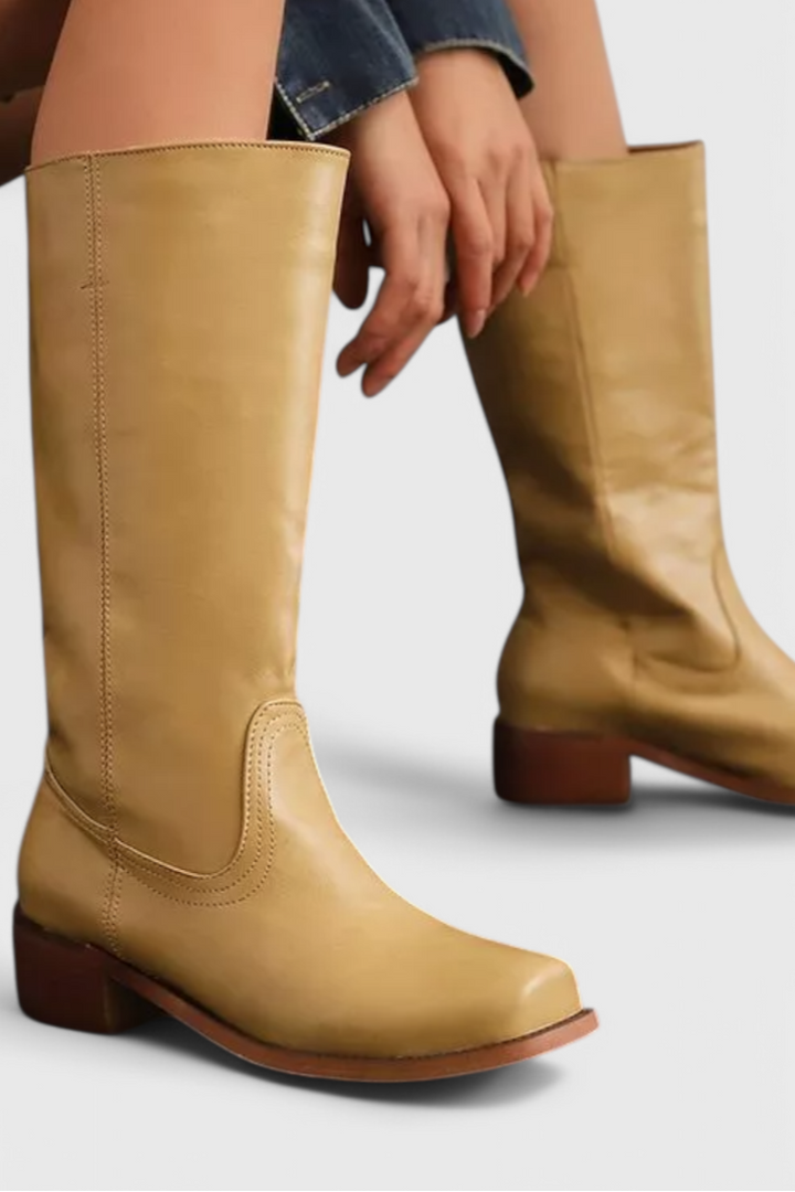 Classic black knee-high leather boots for women, featuring an elegant design & comfortable stacked heel.