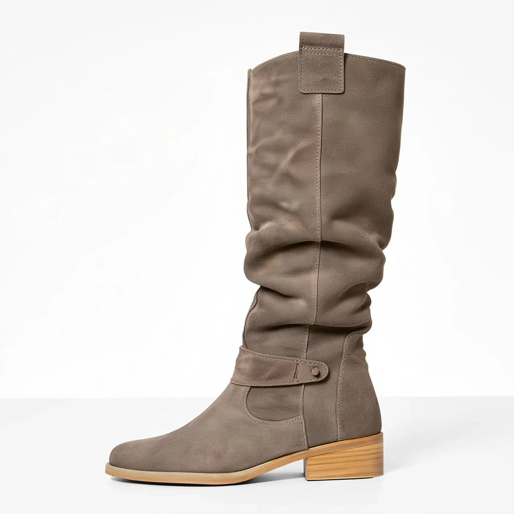Full shot of women's elegant knee-high suede boots, showcasing their sophisticated winter appeal
