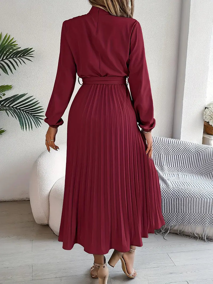 Sophisticated women's long sleeve maxi dress featuring a cinched waist belt and delicate pleats.