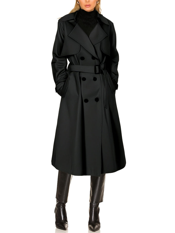 Full shot of a model wearing a chic longline black trench coat, embodying elegant business fashion