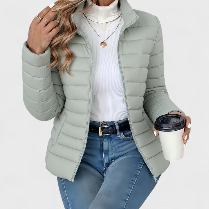 Elegant women's longline quilted jacket with high collar for winter, lightweight and stylish outerwear.