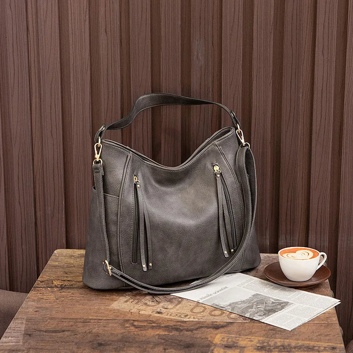 Women's black vegan leather shoulder bag on a white background, highlighting its sleek design