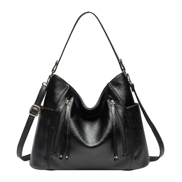 Detail shot of the clasp on a women's luxe vegan leather shoulder bag, secure and chic