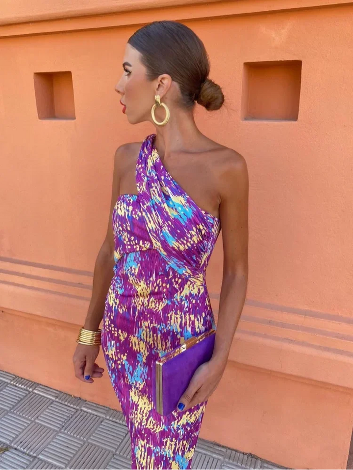 Full shot of a woman wearing a one-shoulder flowy maxi dress, highlighting its elegant summer style.