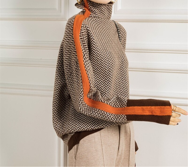Detailed view of the herringbone knit pattern on a women's orange turtleneck sweater, winter fashion staple