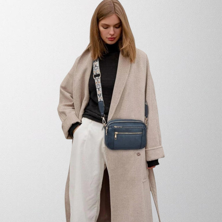 Refined women's multi-compartment handbag worn as a shoulder bag, demonstrating its practicality