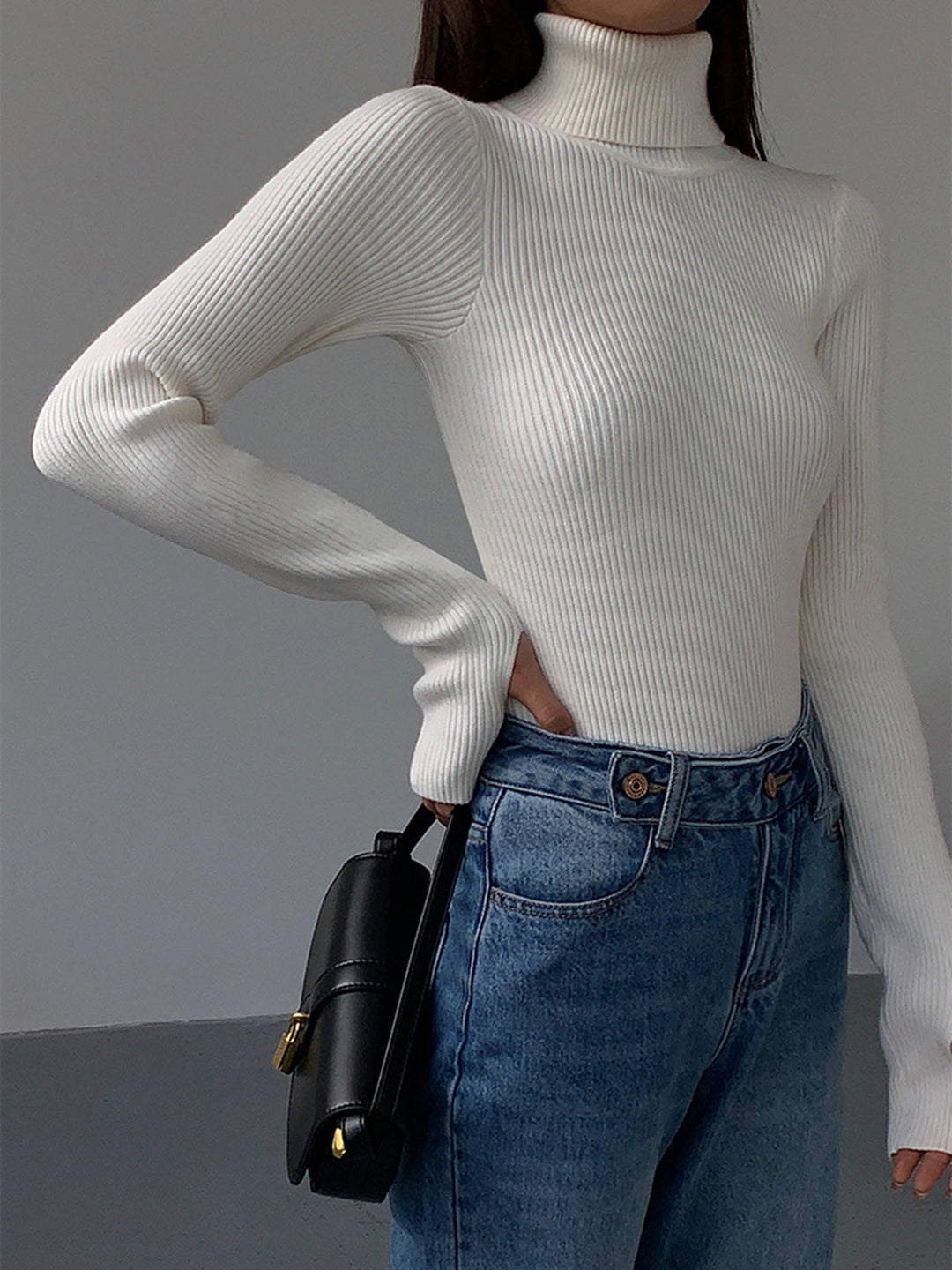 Close-up of the subtle knit pattern on a women's spring ribbed turtleneck sweater.