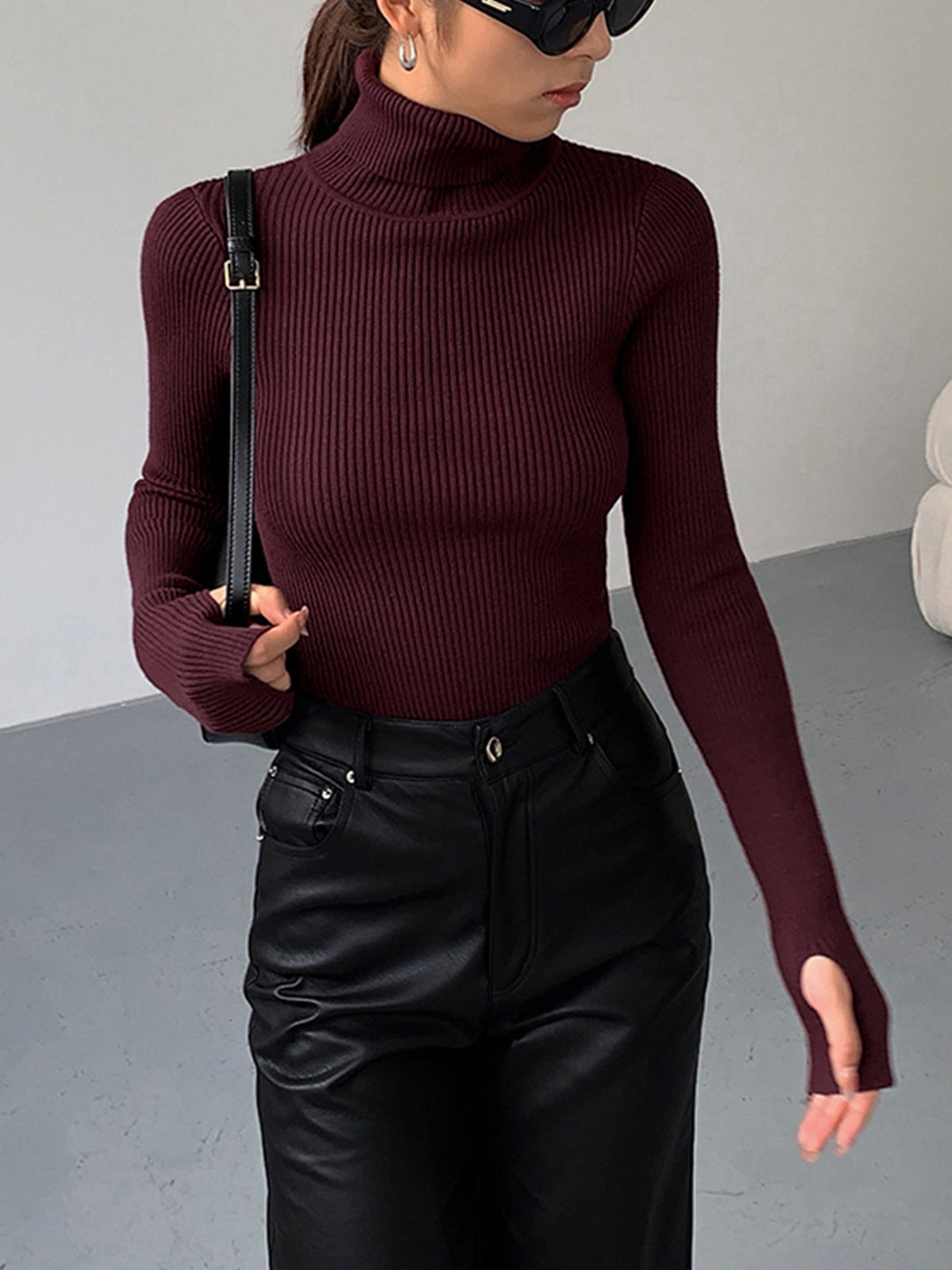 Model wearing a stylish women's ribbed turtleneck sweater, showcasing its elegant fit.