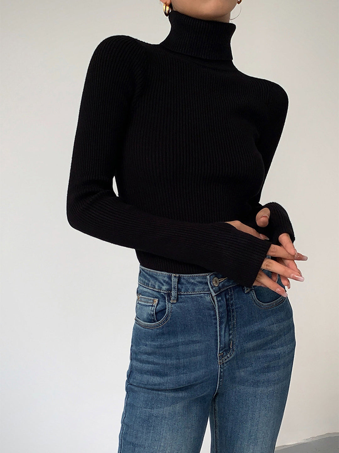 Front view of a women's ribbed turtleneck sweater, highlighting its classic design for spring.
