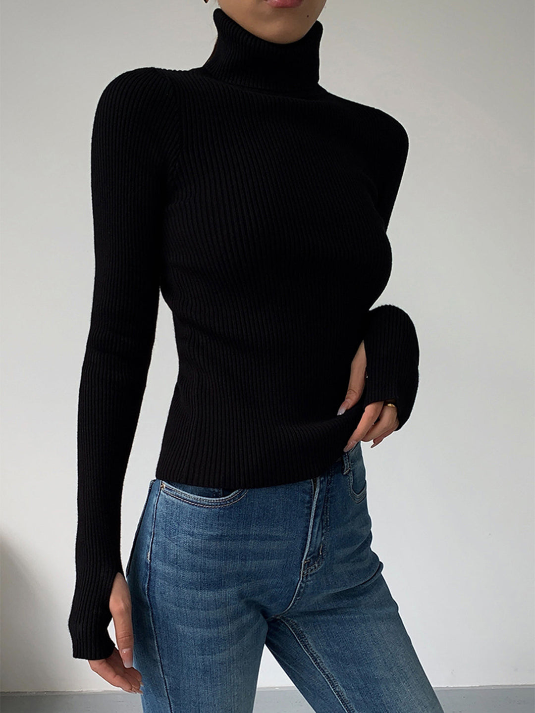 Detail of the turtleneck collar on a women's ribbed spring sweater, a key style feature.