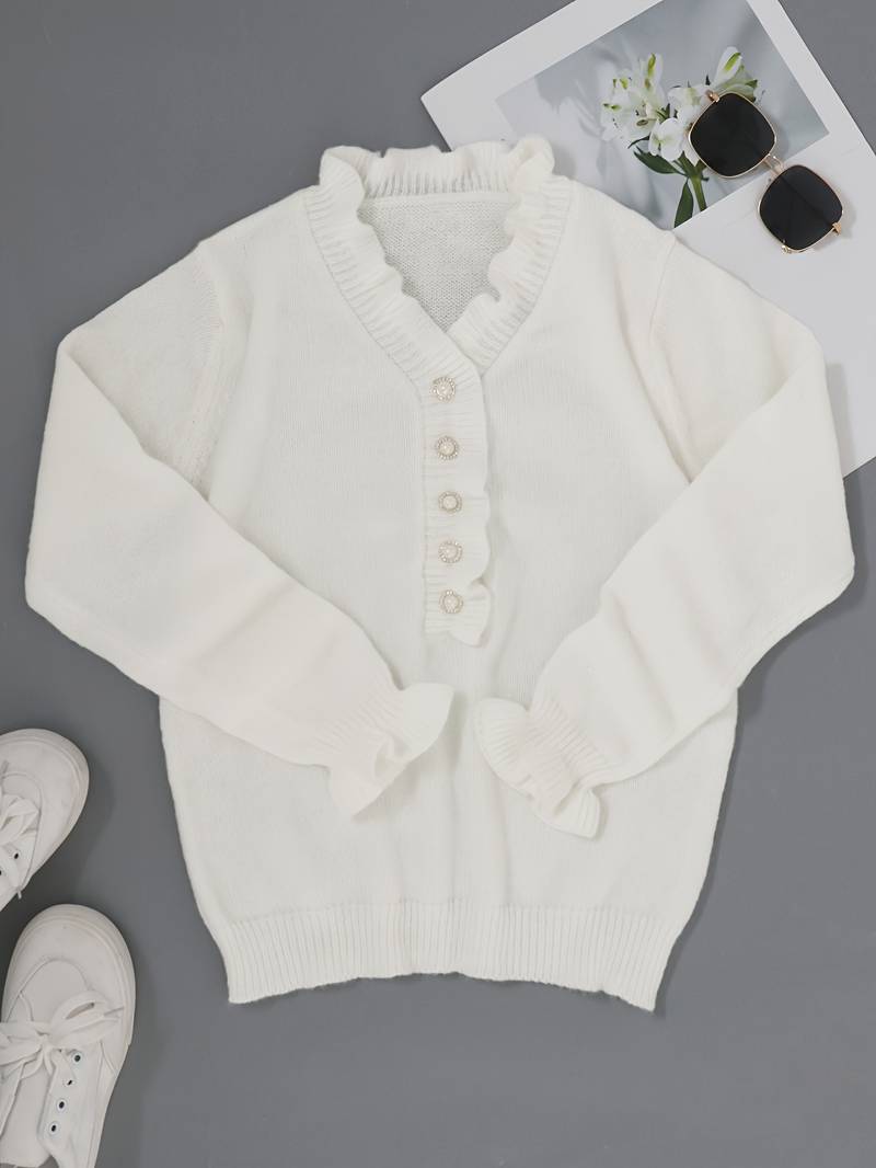 Close-up of a white women's ruffle blouse with delicate fabric and an array of shiny decorative buttons