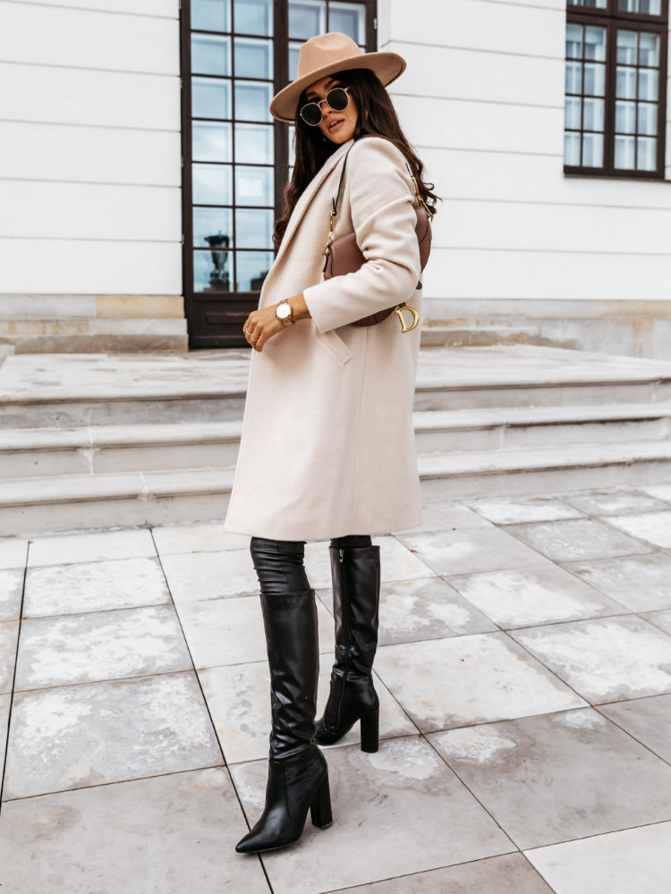 Close-up of a tailored long formal coat with single-breasted button closure, ideal for women's fashion.