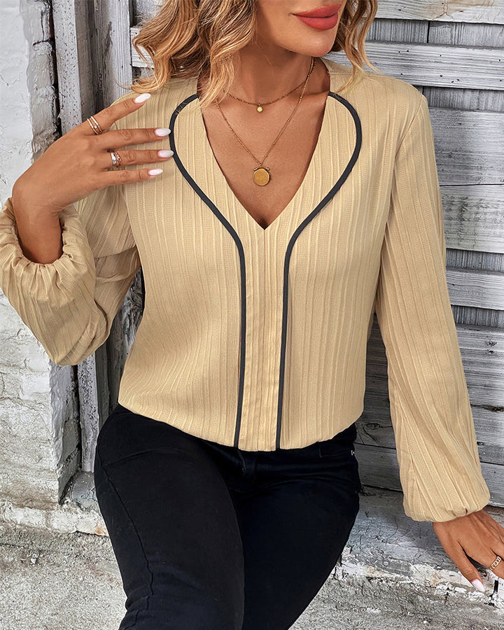 Modern women's long sleeve top, V-neck design with stylish balloon sleeves, ideal for day-to-night fashion.