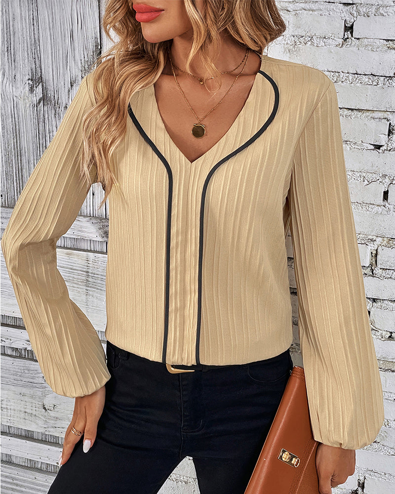 Fashionable women's blouse with an elegant V-neck and distinctive balloon sleeves, suitable for many occasions.