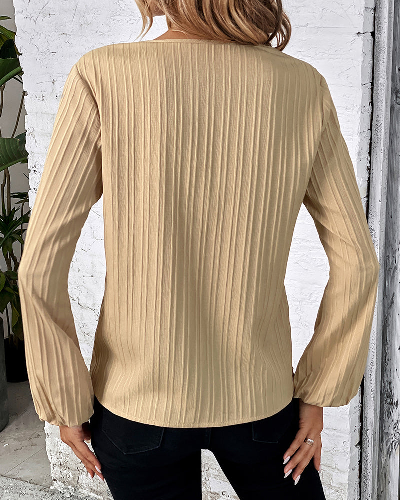 Comfortable women's V-neck top, long balloon sleeves, offering an elegant yet casual fashion statement.