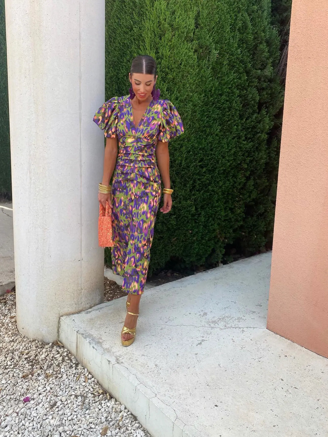 Model wearing a vibrant purple puff sleeve evening dress, posing elegantly for a party or formal gathering.