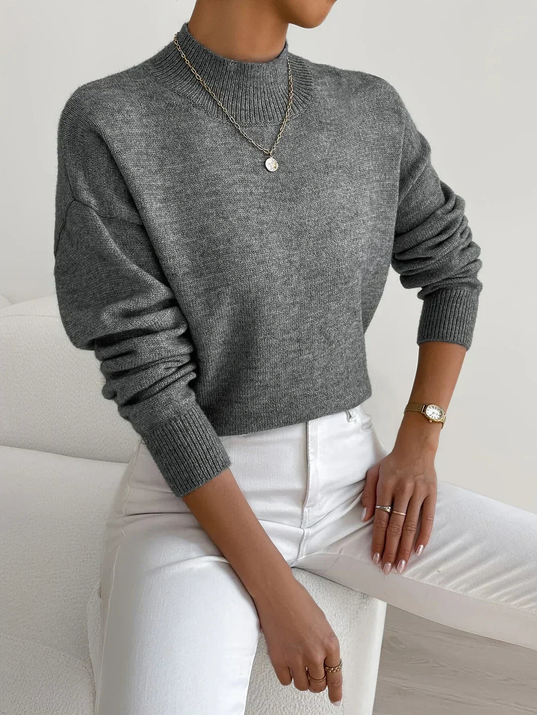 Back view of a women's ivory knitted turtleneck sweater, emphasizing its cozy and chic design