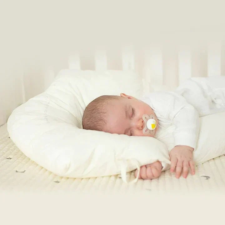 Portable ergonomic baby cuddle cushion, ideal for safe antibacterial sleep support for babies.