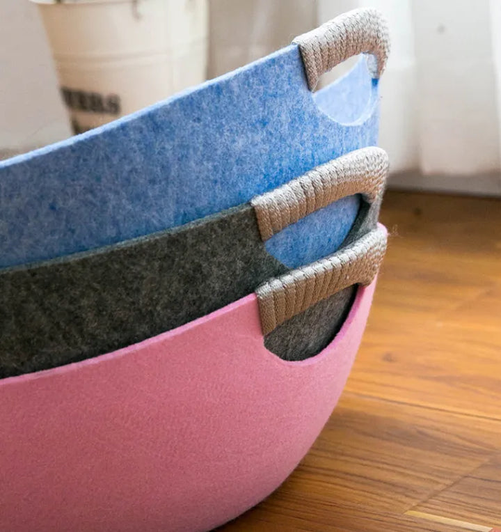 Grey felt cat bed: a stylish, small pet basket with carry handles, perfect for a cozy cat nap anywhere.