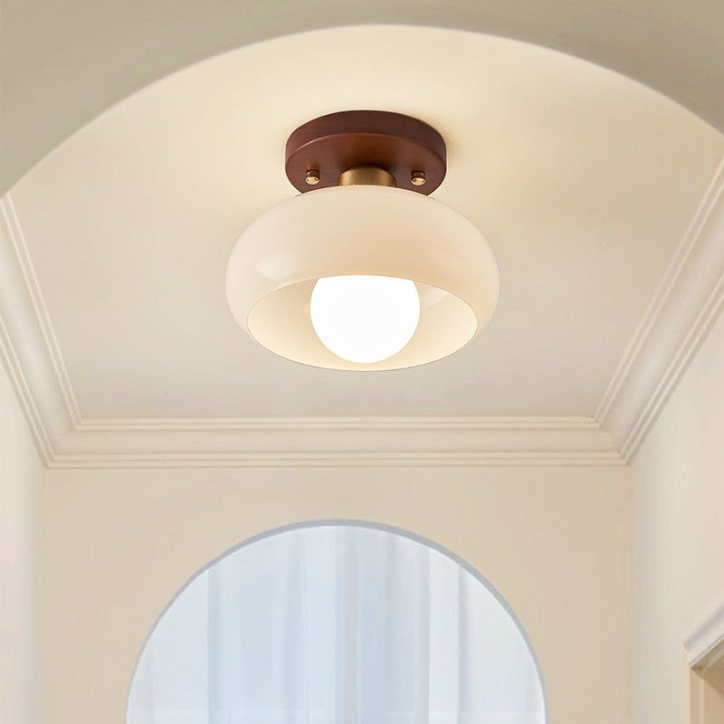 Elegant French Bauhaus ceiling lamp featuring warm wood and opal glass, providing atmospheric light for home decor.