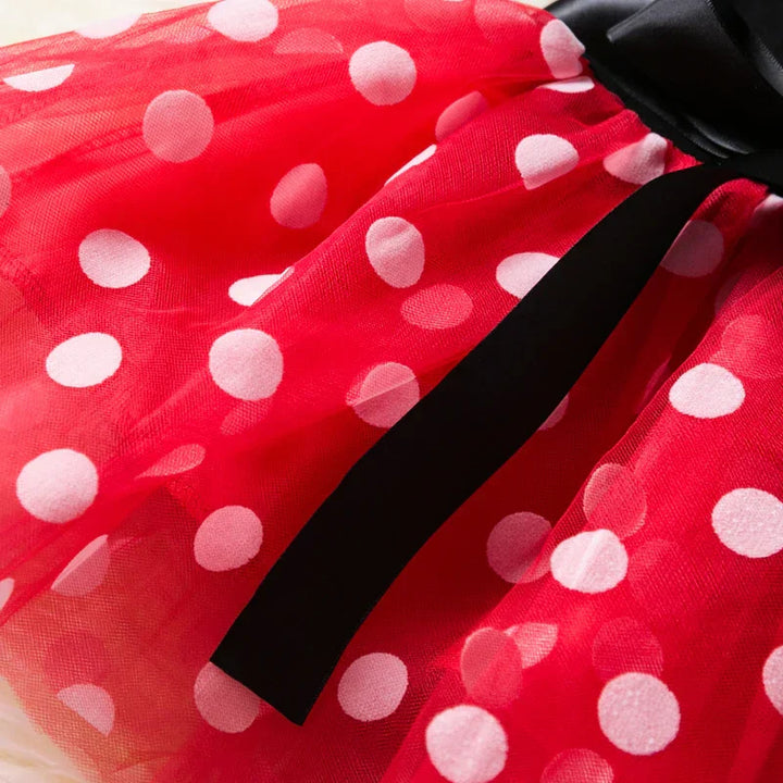 Close-up of a girl's Minnie Mouse polkadot dress with white dots and a cute matching ear headband.