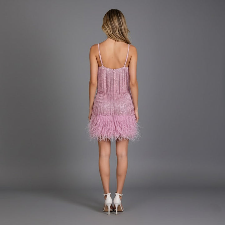 Stylishly posed woman in a red fringe feather mini cocktail dress, ready for an evening event.