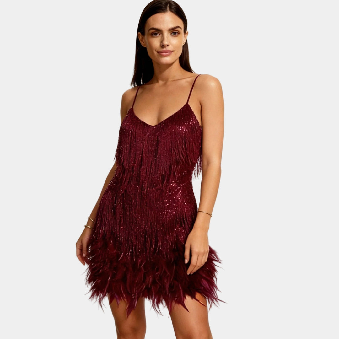 Close-up of shimmery sequin fabric and soft feather accents on a party mini dress.