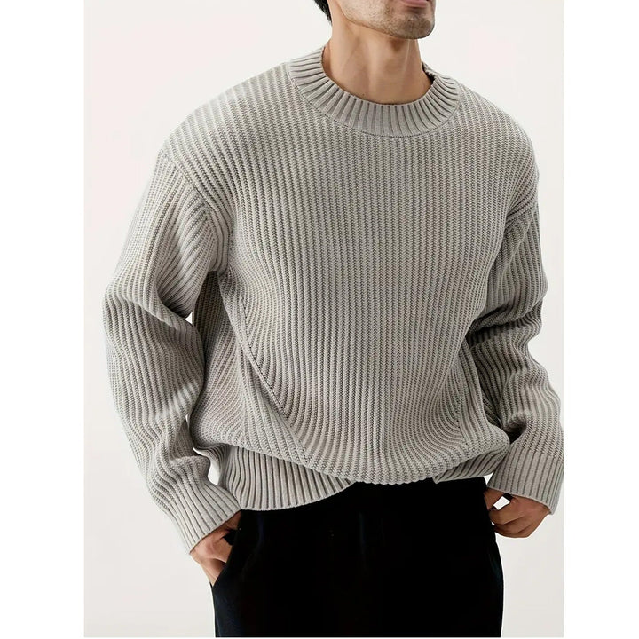Close-up of ribbed knit texture on a grey men's relaxed fit crewneck sweater. Soft, comfortable casual wear.