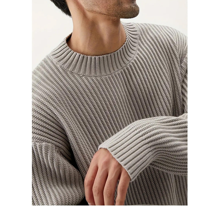 Man wearing a stylish grey relaxed fit crewneck sweater. Perfect for comfortable men's casual, everyday fashion.