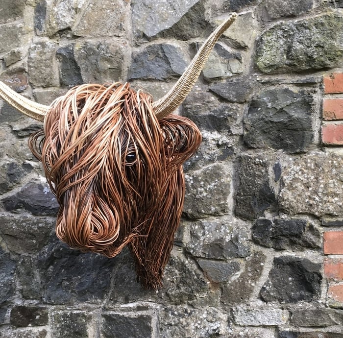 Unique rattan wall sculpture, rustic bull head art for natural, boho-style interior design.