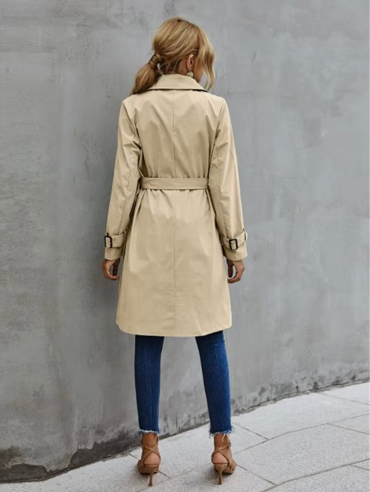 Chic women's trench coat with double-breasted front and belted waist, ideal winter coat.