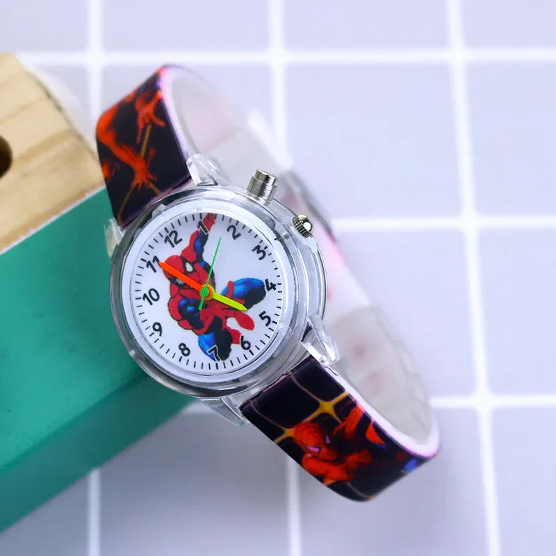 Child wearing a glow-in-the-dark Spider-Man watch, red silicone strap on their wrist.
