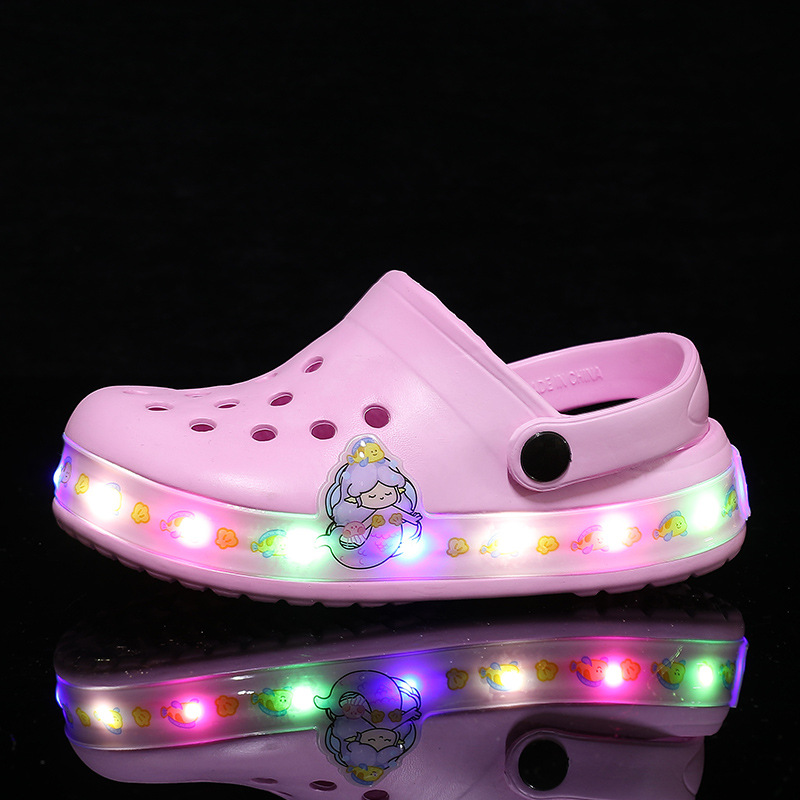 Close-up of glowing kids clogs, illuminating in the dark. Fun, slip-on footwear for children's adventures.