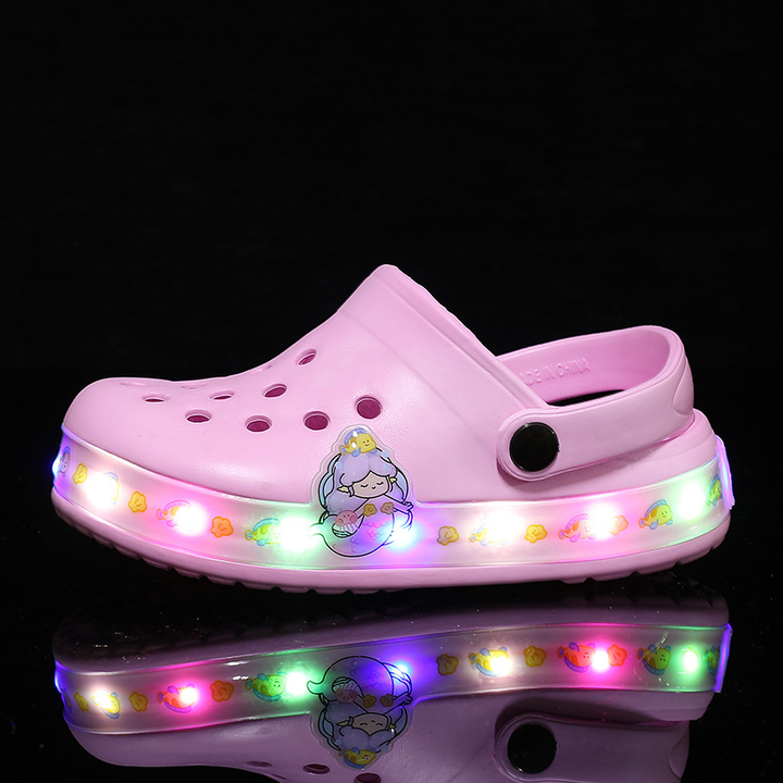 Close-up of glowing kids clogs, illuminating in the dark. Fun, slip-on footwear for children's adventures.