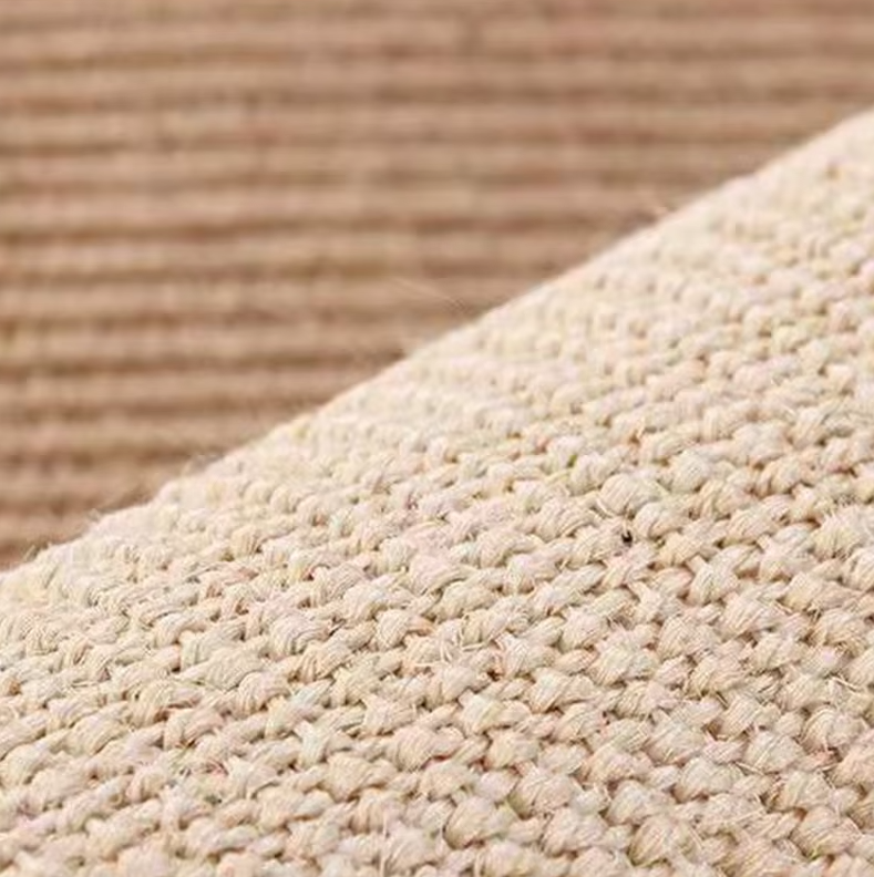 Close-up of the light grey sisal texture on a sofa armrest cat scratch protector.