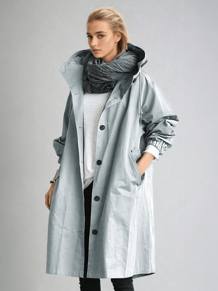 Woman wearing a stylish water-repellent trench coat. Elegant outerwear for transitional weather & chic fashion.