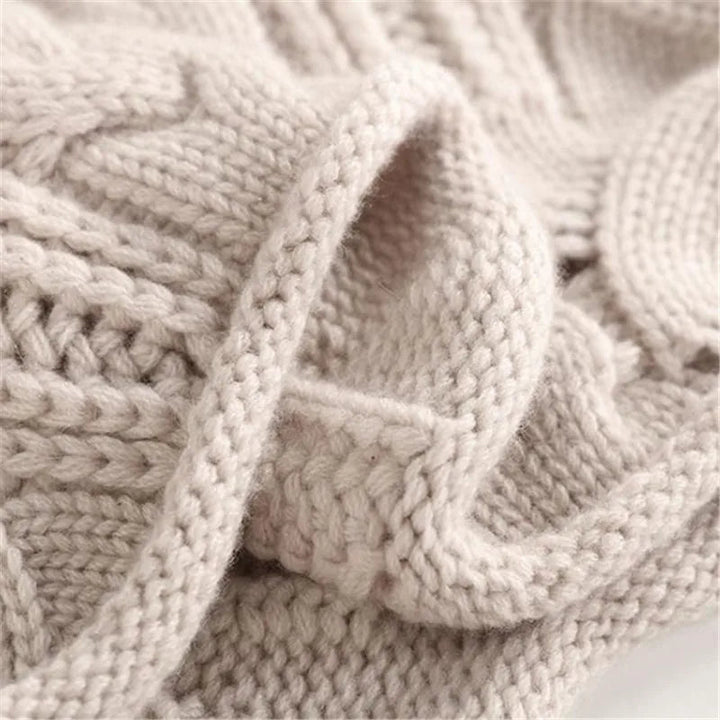Women's luxurious beige cashmere cable knit sweater, perfect for winter fashion.