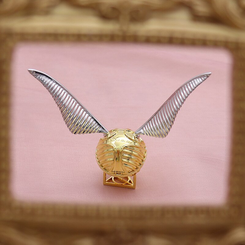 Gold-plated winged orb ring & jewelry case with intricate details, a luxurious & magical storage solution.