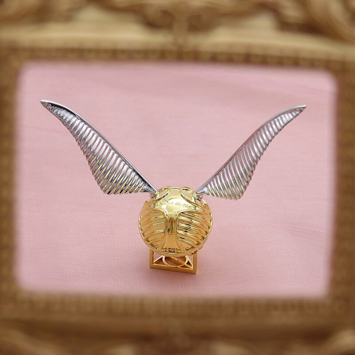 Gold-plated winged orb ring & jewelry case with intricate details, a luxurious & magical storage solution.