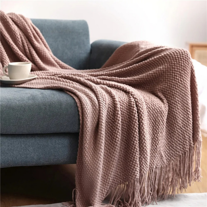 Acrylic throw blanket, merino-style luxury with decorative tassels for a chic living space.