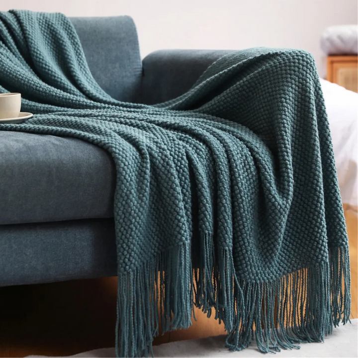 Decorative soft throw blanket with tassels, offering merino-style comfort for any room.