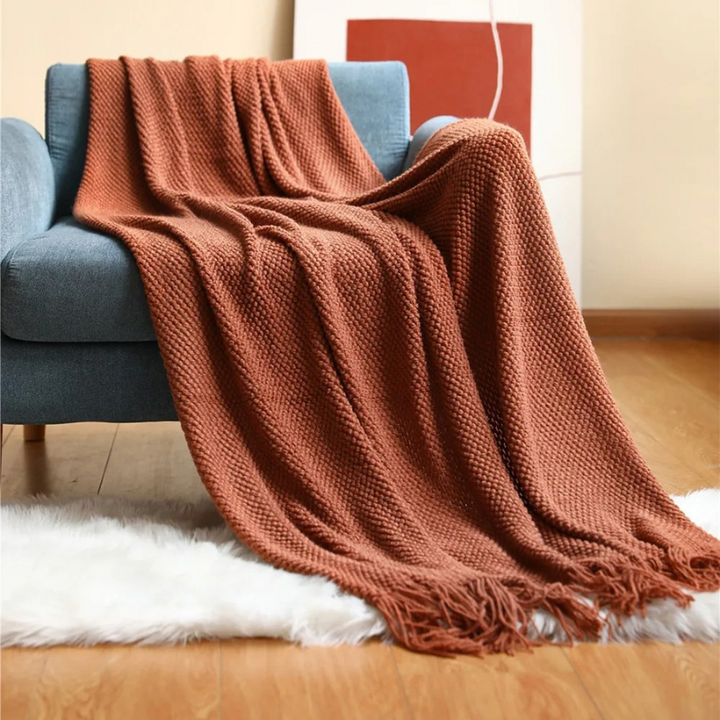 Stylish modern throw blanket with tassels, a cozy and luxurious merino-style home decor piece.