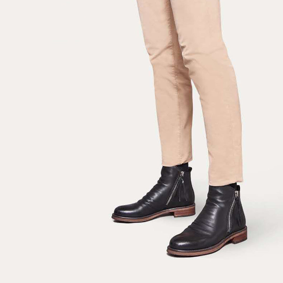 Close-up of the side zip closure on men's black leather ankle boots, highlighting craftsmanship.