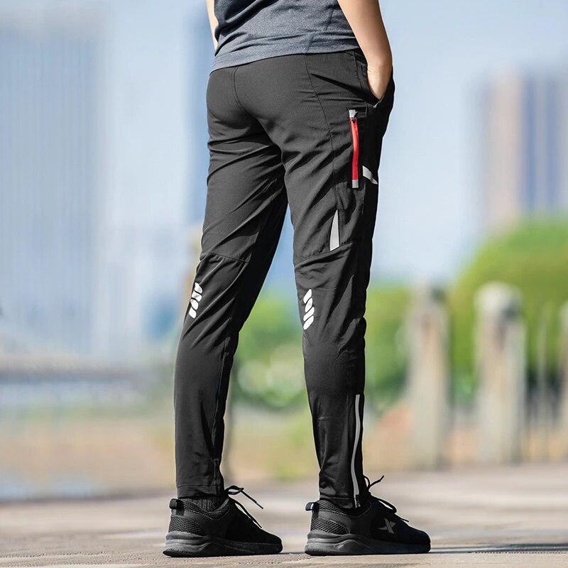 Men's stretch performance bike pants, moisture-wicking with tapered fit & reflective details for safety.