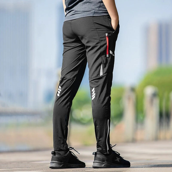 Men's stretch performance bike pants, moisture-wicking with tapered fit & reflective details for safety.