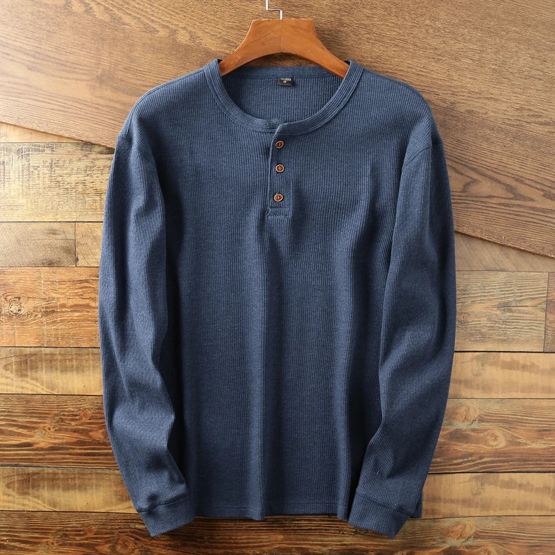 Detail of the breathable waffle structure on a men's long sleeve Henley shirt.