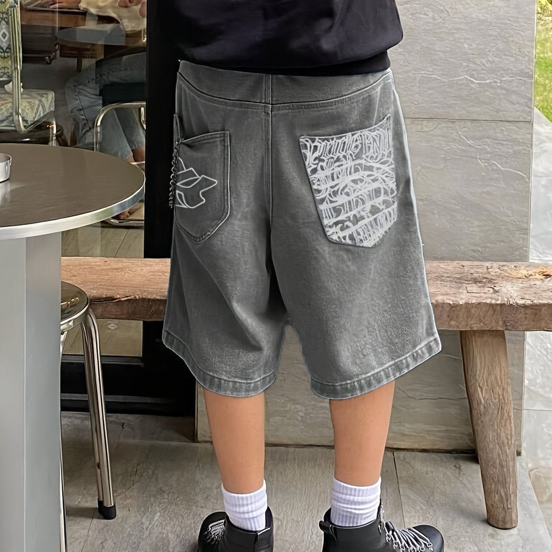 Trendy men's loose fit denim shorts, knee-length Bermuda style with fashionable floral embroidery.
